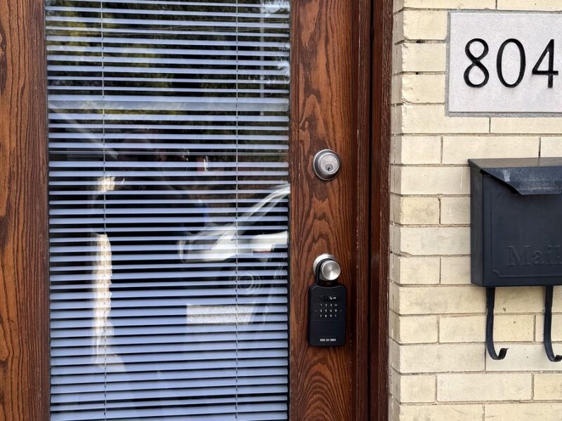 Front door with a deadbolt, a realtor lockbox on the handle and a mailbox beside it