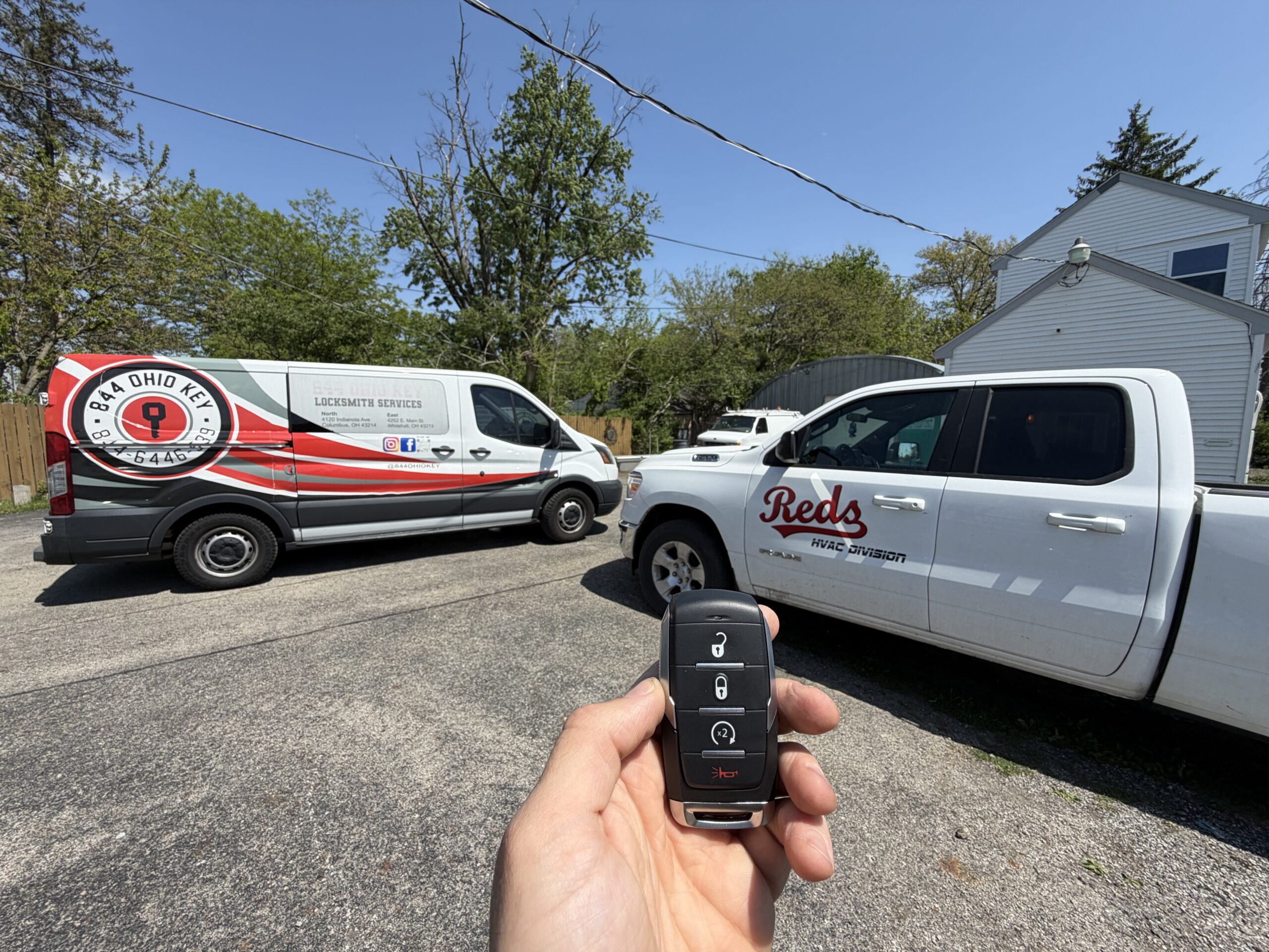 Locksmith holding new Dodge Ram key next to wrapped 844 Ohio Key van after car key replacement service in Grove City Columbus Ohio.