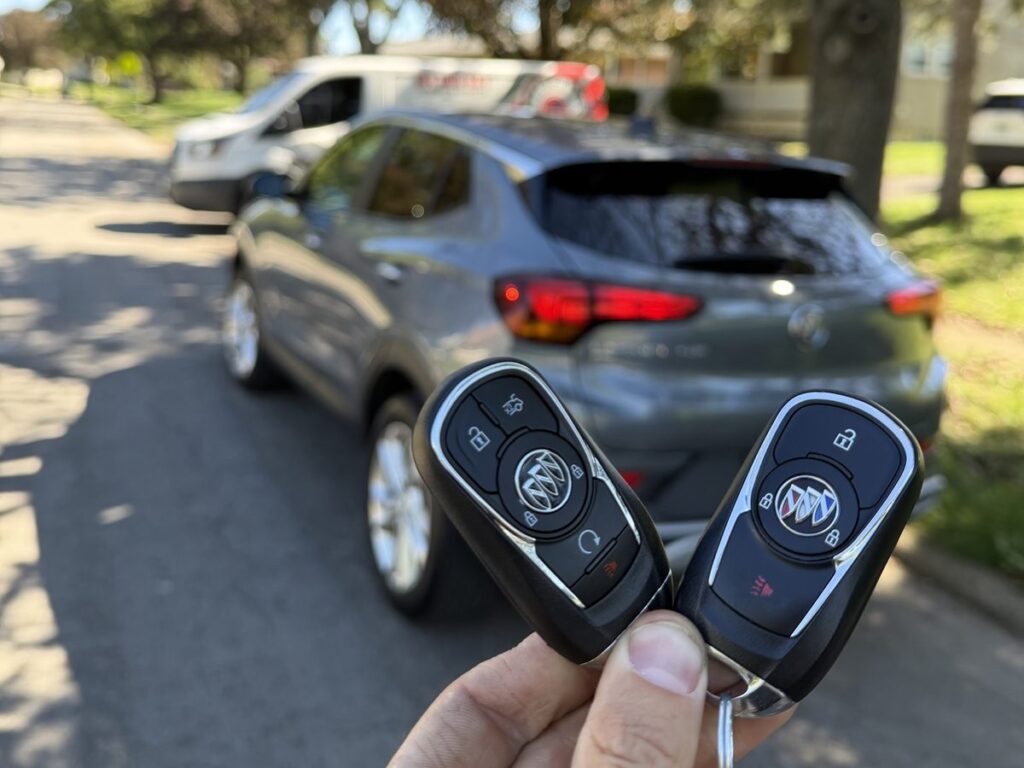 Original 2021 Buick Encore key fob without remote start next to the new fob with a remote start button