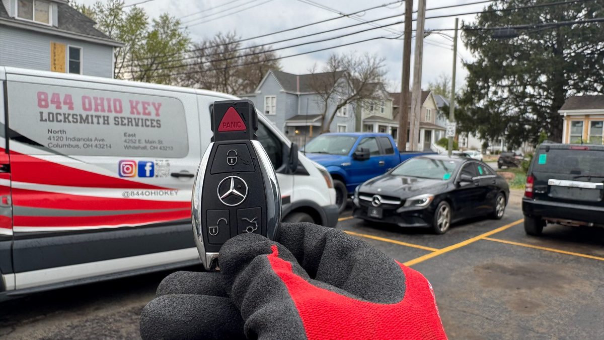Mercedes-Benz key held beside the customer’s car with the 844 Ohio Key van behind it