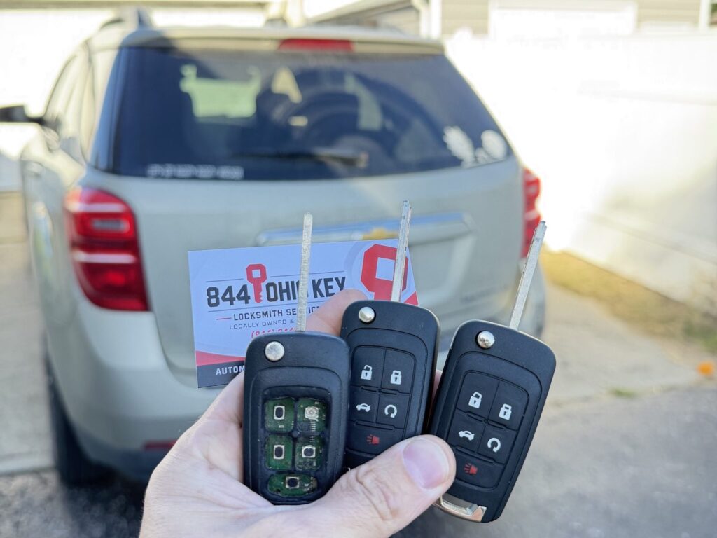 Original worn Chevrolet key beside the new replacement key at the customer’s vehicle