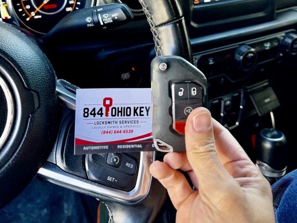 2022 Jeep Wrangler push-to-start key fob held next to the start button with an 844 Ohio Key business card