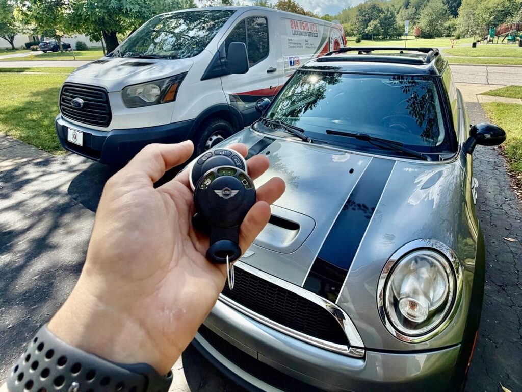 Worn original 2010 MINI Cooper key fob next to the replacement the owner bought online